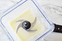 a blender filled with yellow liquid on top of a marble counter