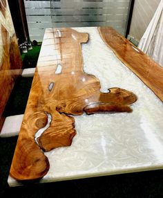 a table made out of wood with white and brown designs on it's surface