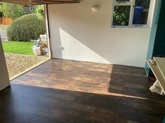 the inside of a house with wood flooring and sliding glass doors that lead out to a yard