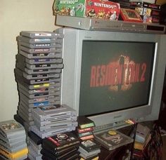 a bunch of video games stacked on top of each other in front of a television