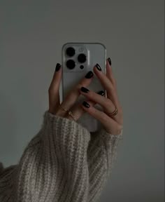 a woman taking a selfie with her cell phone in front of her face and hands