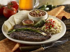 a plate with steak, rice and beans on it