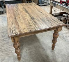 an old wooden table in a shop with tools on the workbench behind it