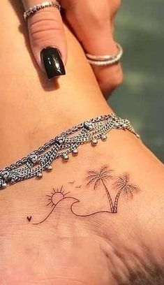 a woman's foot with a small palm tree tattoo on her left side ankle