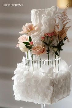 a three tiered wedding cake with flowers on top and ruffled layers in the middle