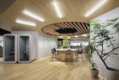 an office with wood flooring and white walls is pictured in this image, there are several chairs around the table