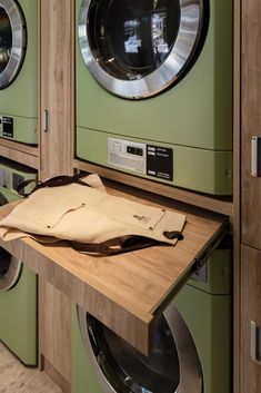 a green washer and dryer sitting next to each other on top of a wooden counter