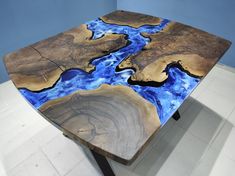 a table made out of wood with blue paint on it's surface and black metal legs