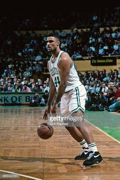 a basketball player dribbling the ball during a game in front of an audience