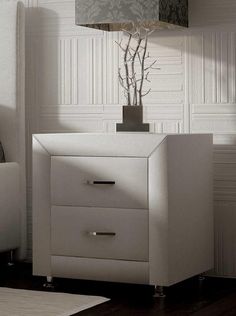 a white night stand with two drawers and a lamp on the end table next to it