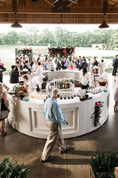 A white round bar set up in an open air patio, surrounded by happy guests. Cocktail Set Up Wedding, Bar Design For Wedding, Cocktail Bar Wedding Receptions, Bars For Wedding Reception, Cocktail Party Setup Ideas, Rooftop Cocktail Hour Wedding, Wedding Bar Outside, Cocktail Hour Photo Backdrop, Wedding At A Mansion