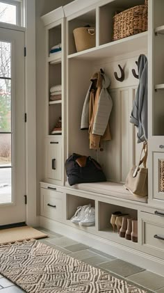 Modern entryway storage system with built-in shelves, coat hooks, and seating bench in a modern home, showcasing organization and functionality. Mudroom Hooks And Bench, Modern Entryway Storage, Organized Entryway, Foyer Storage, Cottage Entryway, Front Hall Closet, Seating Bench