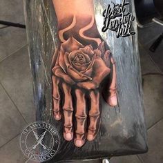 a hand with a rose tattoo on it