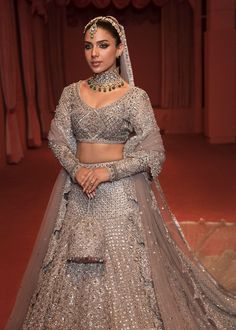 The embellished Bridal Grey Lehenga Choli and Dupatta Dress is a magnificent masterpiece that gives the gorgeous bride a head-turning appearance on the big day. Sequins, cut-dana, and embroidery work make this beautiful Lehenga Dress an epitome of beauty and grace. Choli: The beautifully embellished choli in an alluring grey shade is a stunning choice to pair with Lehenga. The choli comes in net fabric. Embroidery and naqshi give a royal touch to this beautiful choli. Cut-dana, pipes, and sequin Grey Lehenga Blouse Designs, Silver Lengha Bridal, Hussain Rehar, Lehenga Top, Dupatta Dress, Beautiful Lehenga, Lehenga Dress, Lehenga Bridal