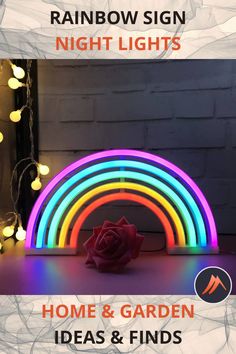 the rainbow sign is lit up with colorful lights and a rose on it's side