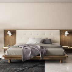 a large bed sitting on top of a wooden platform next to a wall mounted lamp