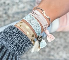 a close up of a person's arm with bracelets and hearts on it