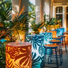 an outdoor dining area with blue and orange chairs, palm trees and potted plants