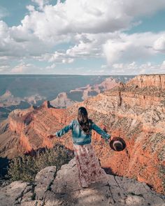 a woman standing at the edge of a cliff