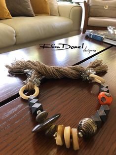 a wooden table topped with lots of different types of bracelets and rings on top of it