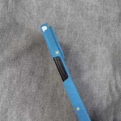 a blue and black pen sitting on top of a gray cloth with stars painted on it