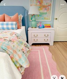 a bedroom with blue walls and pink rugs on the floor, white bedding and two nightstands