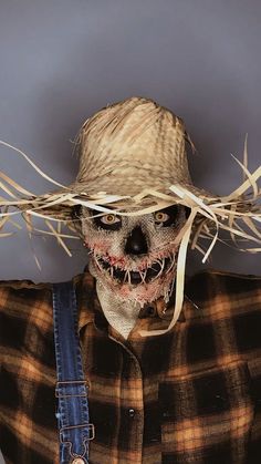 a scarecrow wearing a straw hat and overalls