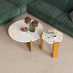 a living room with a green couch and two small tables on the carpeted floor