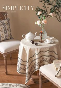 a table with two chairs and a vase filled with flowers sitting on top of it