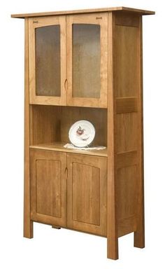 a wooden hutch with glass doors on the top and bottom shelf, holding a plate