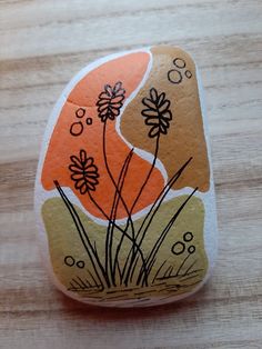 a rock with flowers painted on it