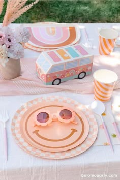 a table topped with plates and glasses next to a vase filled with flowers on top of a