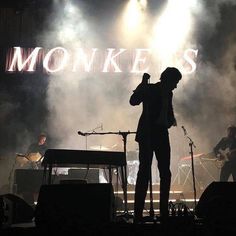 a man standing on top of a stage holding a microphone in front of a crowd