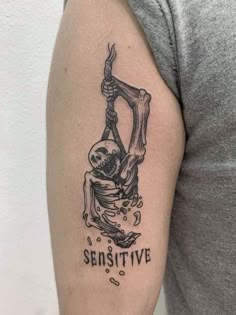 a man with a tattoo on his arm that reads, selvesive and is holding a skeleton