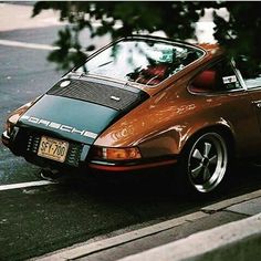 an orange car is parked on the side of the road