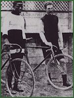 two men standing next to each other with their bikes