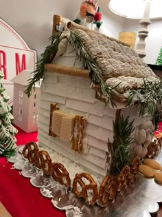 a gingerbread house made to look like a train with pretzels on the tracks