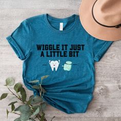 a t - shirt that says wiggle it just a little bit next to a hat