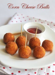 small appetizers with toothpicks on a white plate next to dipping sauce