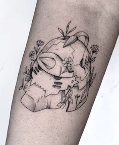 a tattoo on the leg of a woman with flowers and an animal head in it