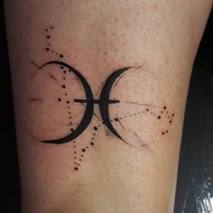 a tattoo on the leg of a woman with two circles and stars around it,