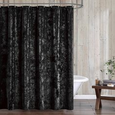 a black shower curtain in a bathroom with wood paneled walls and tile flooring