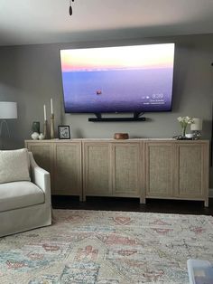 a large flat screen tv mounted to the side of a wall in a living room