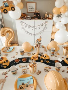 a table set up for a construction themed birthday party with balloons, plates and decorations