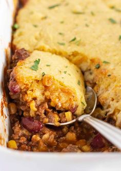 a casserole dish with meat and vegetables in it, being spooned into the casserole