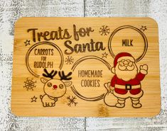 a wooden cutting board with santa and reindeers on it, says treats for santa