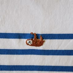 a towel with a sloth on it laying on top of blue and white stripes