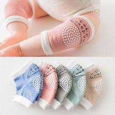 four pairs of baby socks with different designs on the arms and feet, all in pastel colors