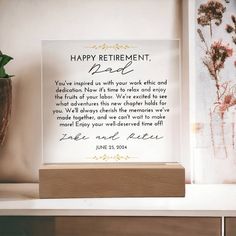 a sign that says happy retirement next to a potted plant and vase with flowers