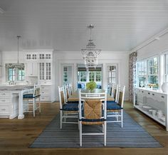 a dining room table with chairs and a rug on the floor in front of it